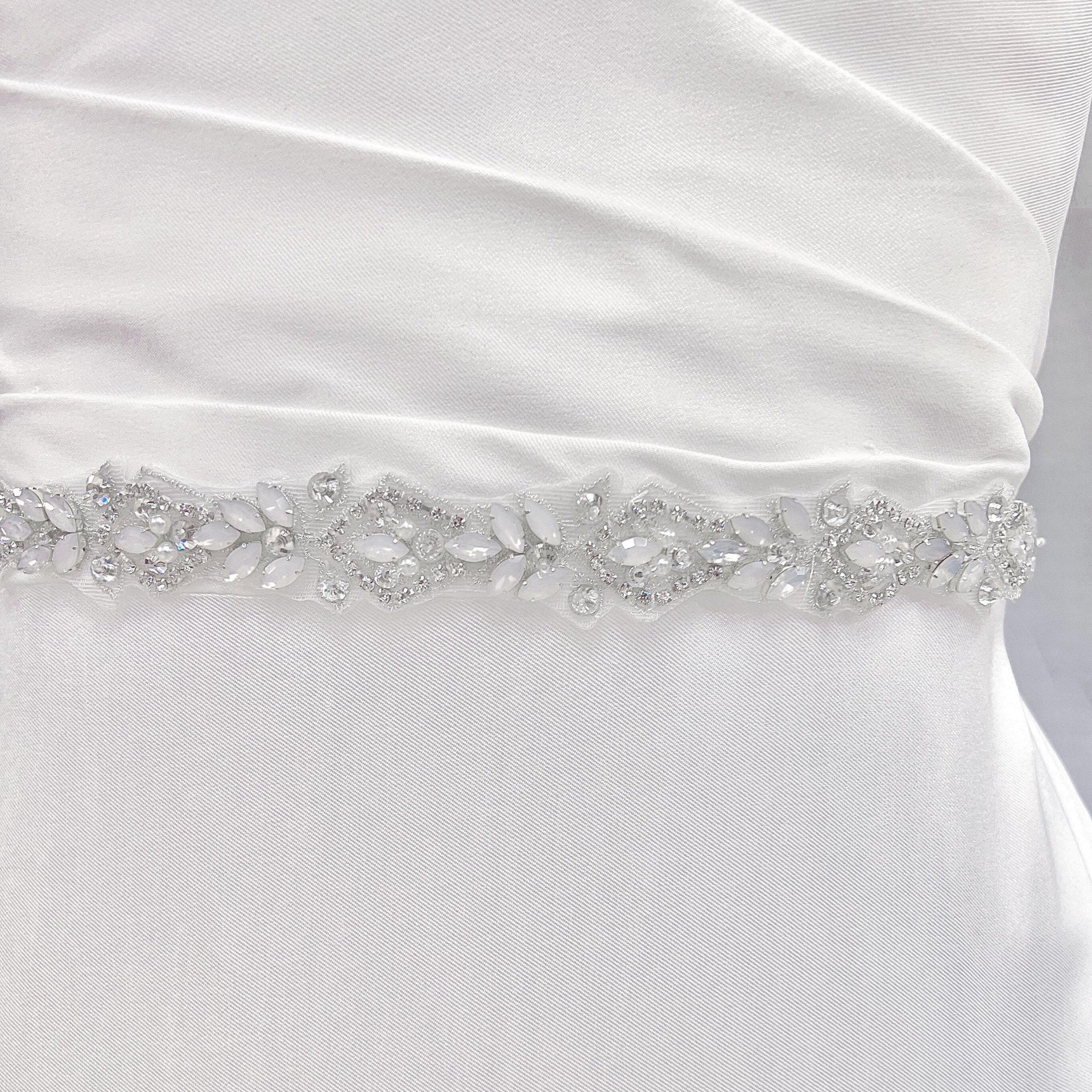 Close-up view of the silver rhinestone and pearl bridal belt showcasing the detailed floral crystal patterns.