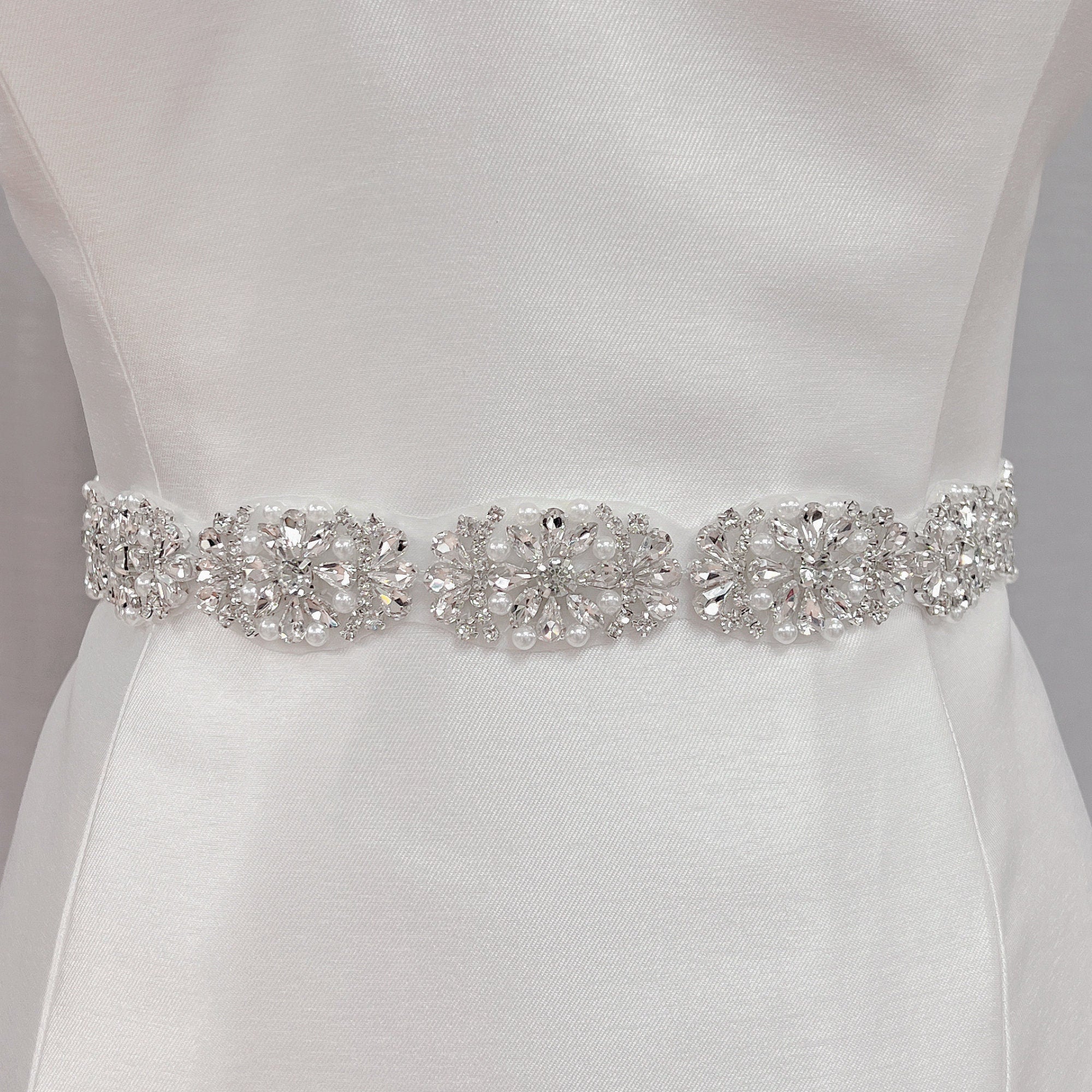 Full-length view of a silver rhinestone and pearl bridal belt.