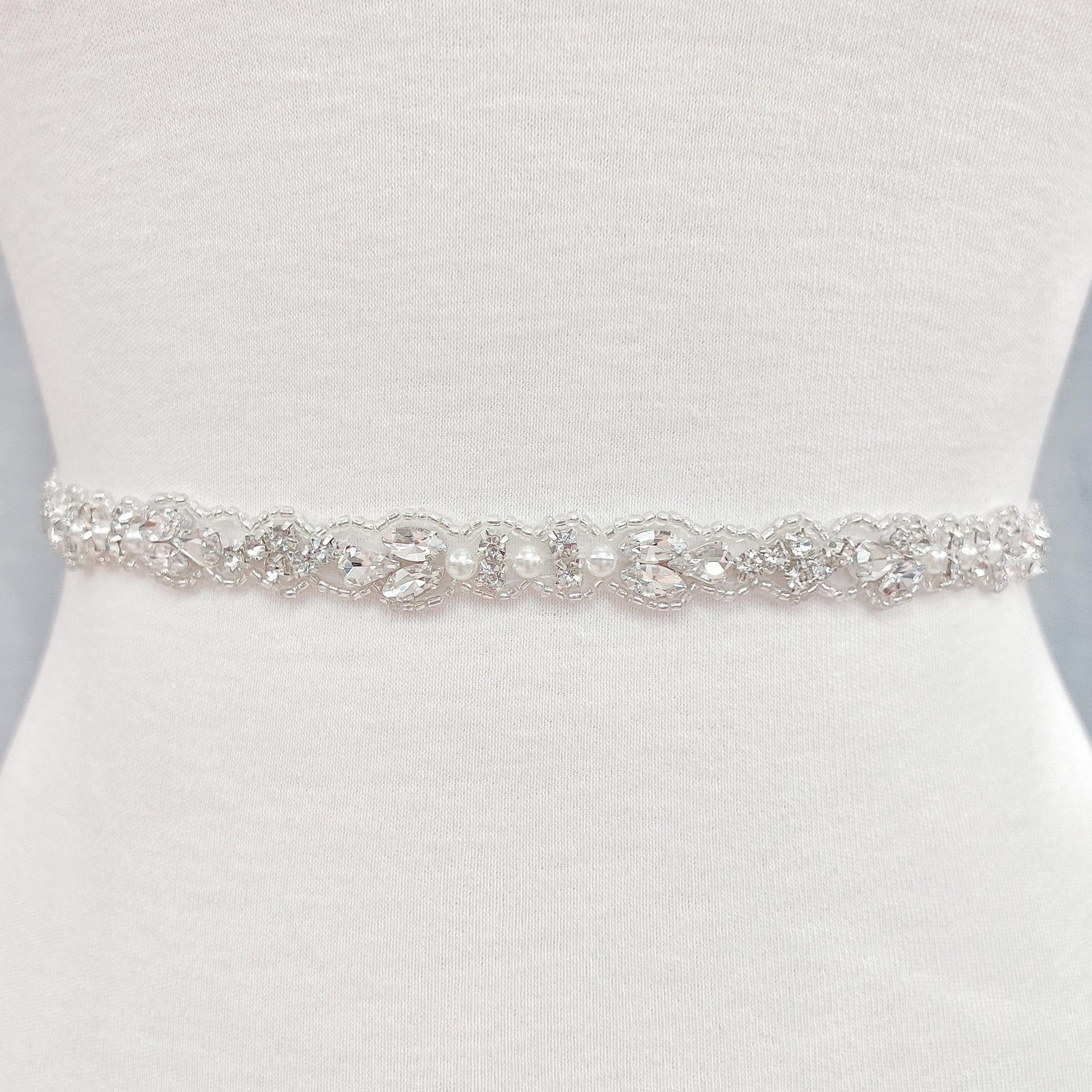 Detail view of a sparkling silver rhinestone and pearl bridal belt.