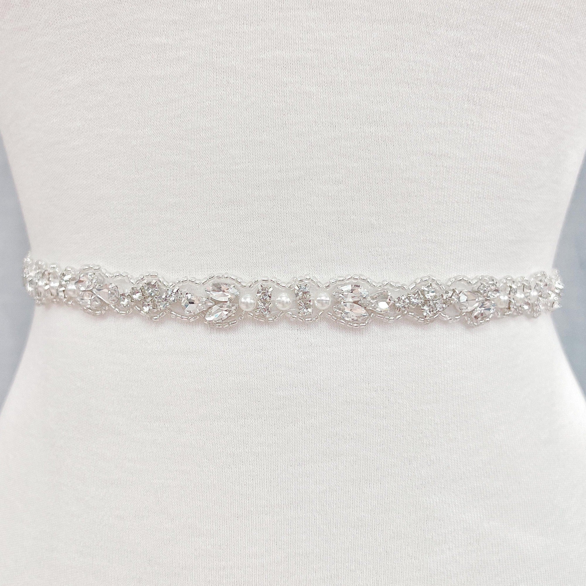 Detail view of a sparkling silver rhinestone and pearl bridal belt.