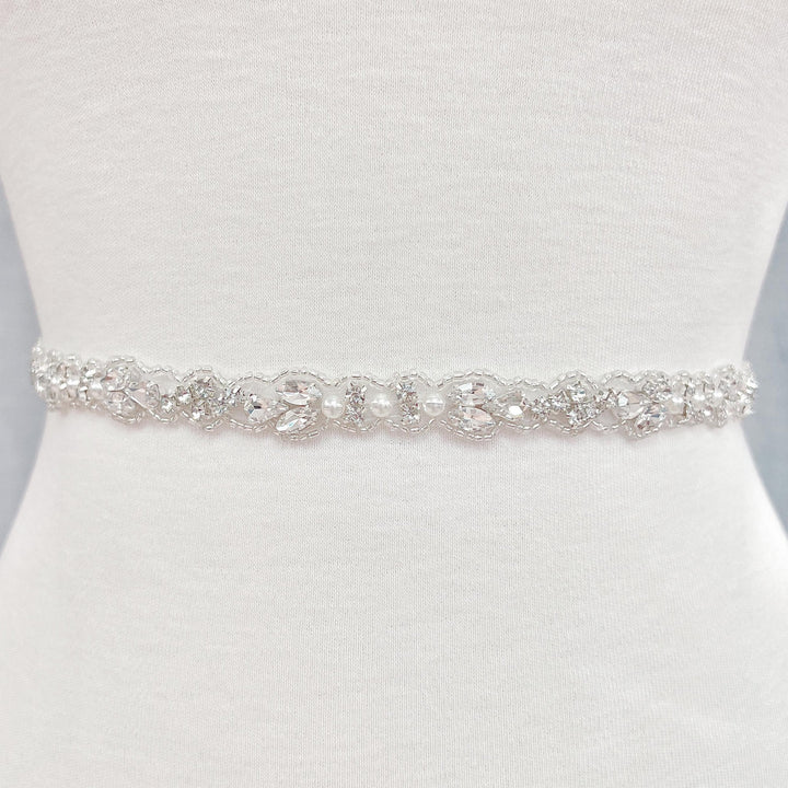 Detail view of a sparkling silver rhinestone and pearl bridal belt.
