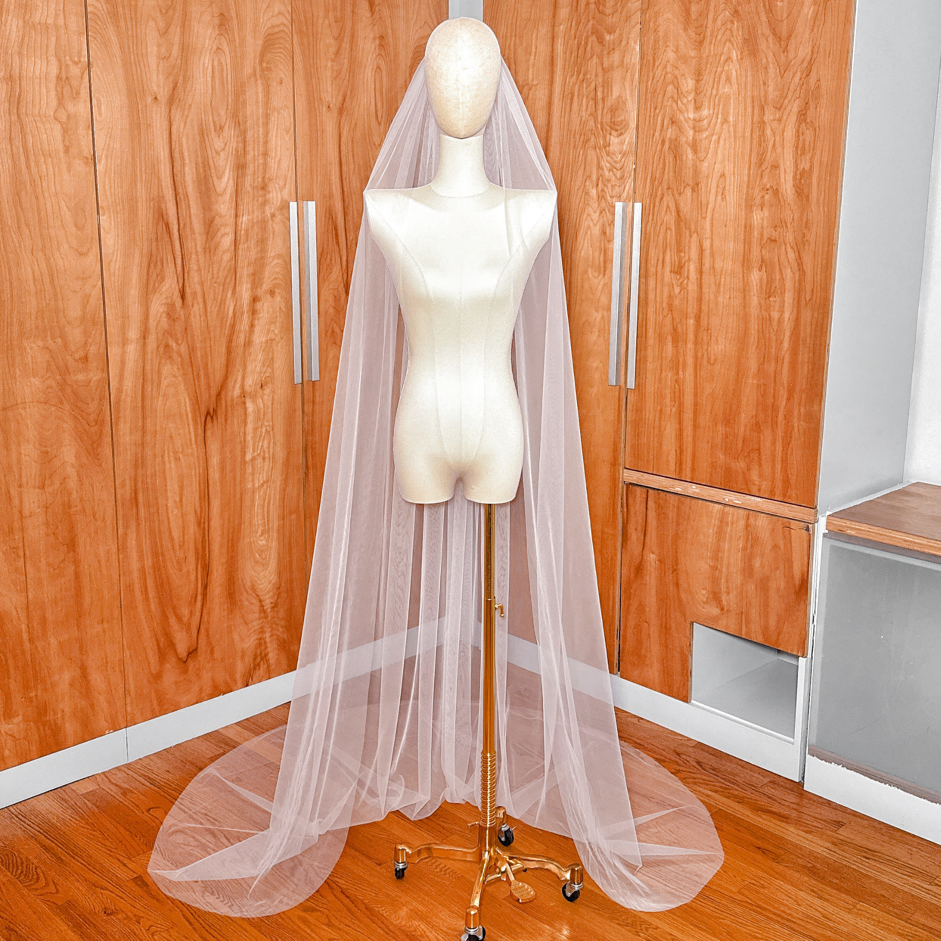 Front view of a simple chapel length raw edge veil showing the sheer, floor-length drape.