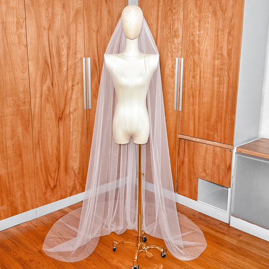 Front view of a simple chapel length raw edge veil showing the sheer, floor-length drape.