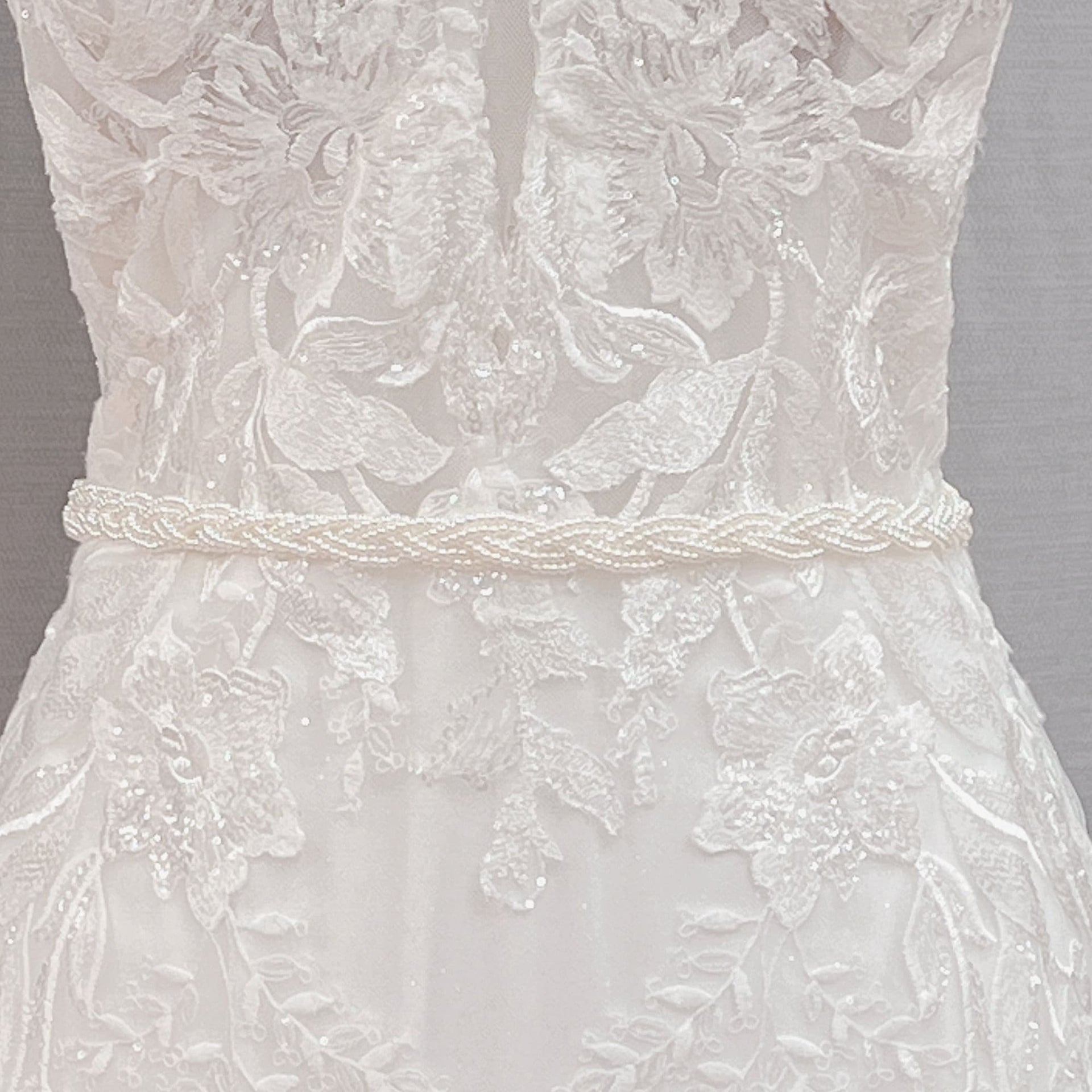 Close-up details of the Simple Pearl Bridal Belt and minimalist white wedding sash on a studio mannequin.