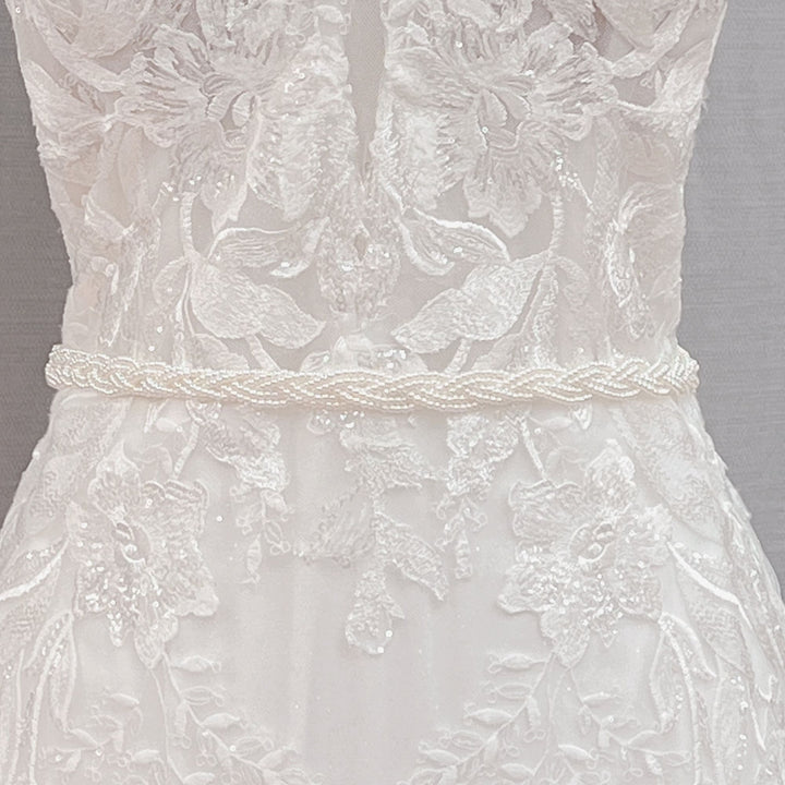 Close-up details of the Simple Pearl Bridal Belt and minimalist white wedding sash on a studio mannequin.