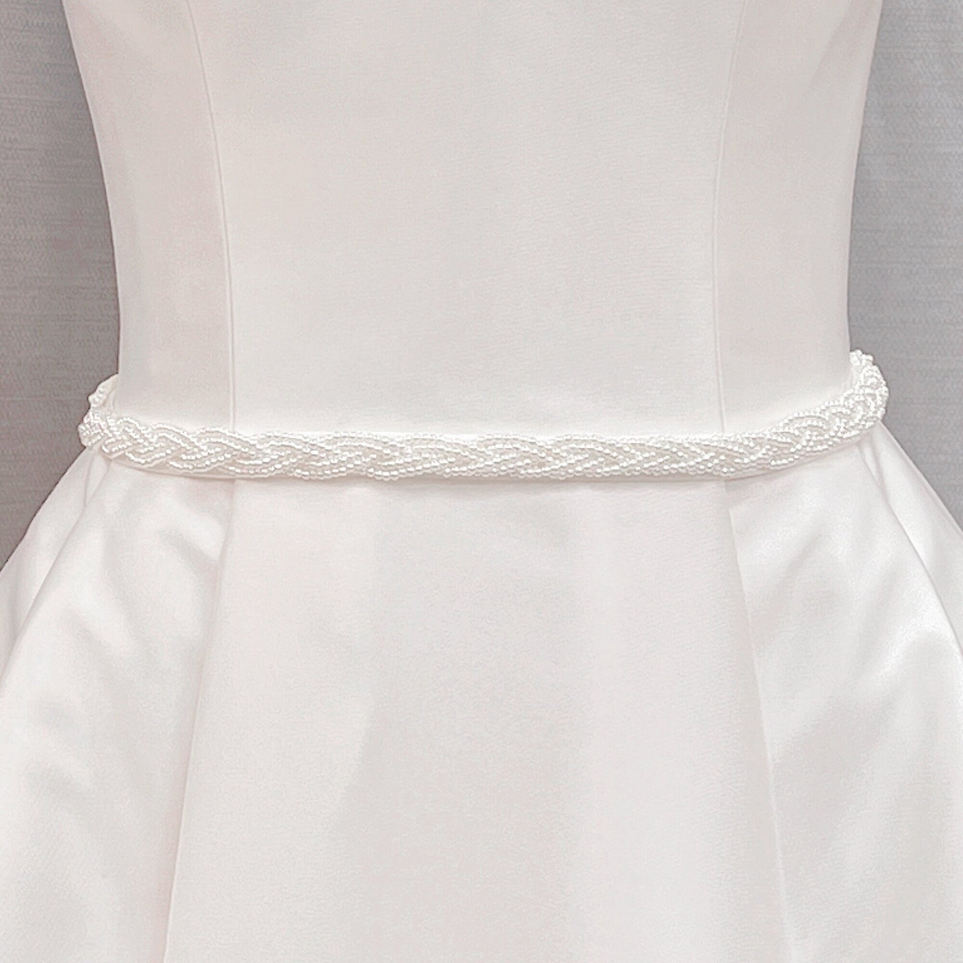 Simple Pearl Bridal Belt with a minimalist white wedding sash displayed on a bridal mannequin.