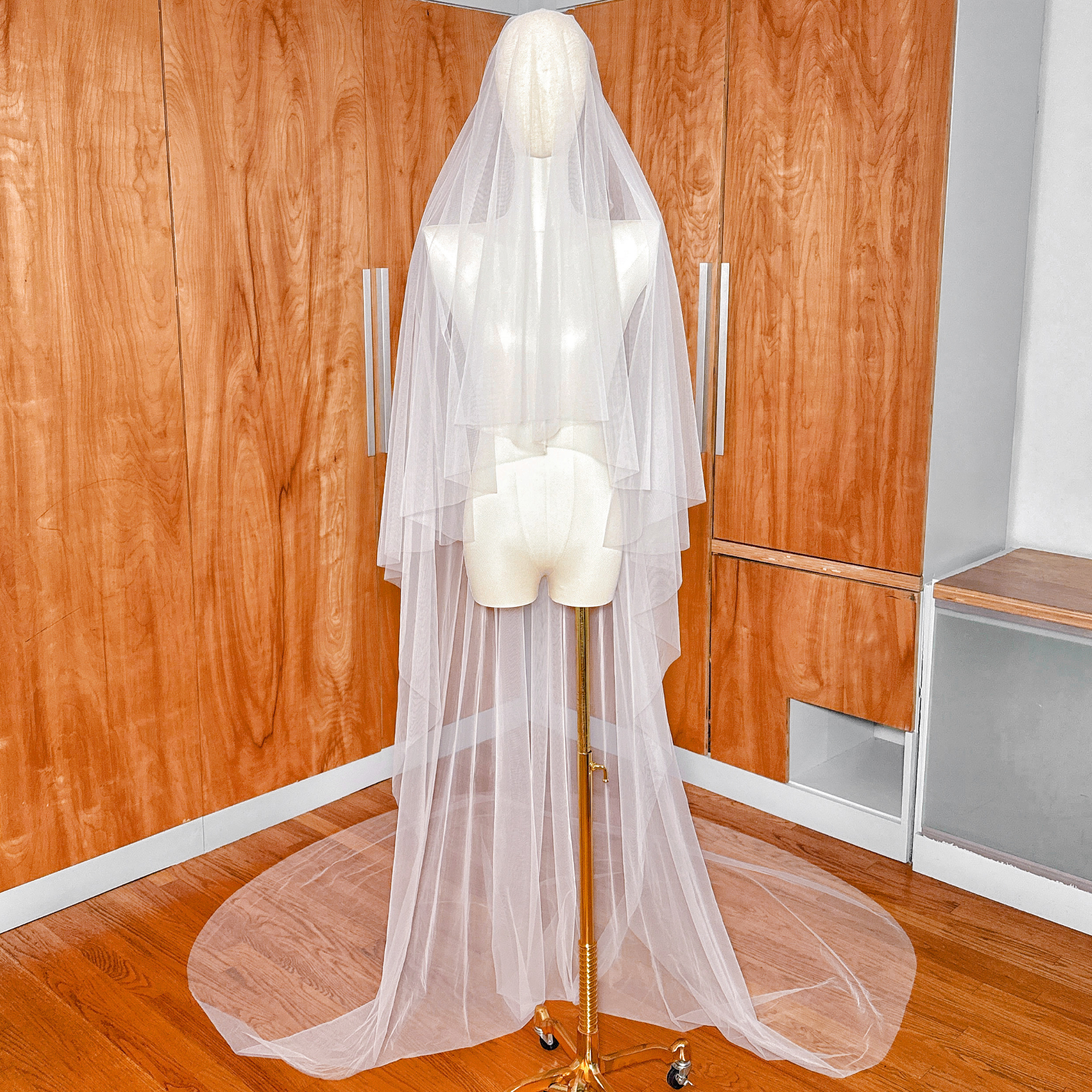 Front view of a simple soft two-tier cathedral length wedding veil displayed on a mannequin.