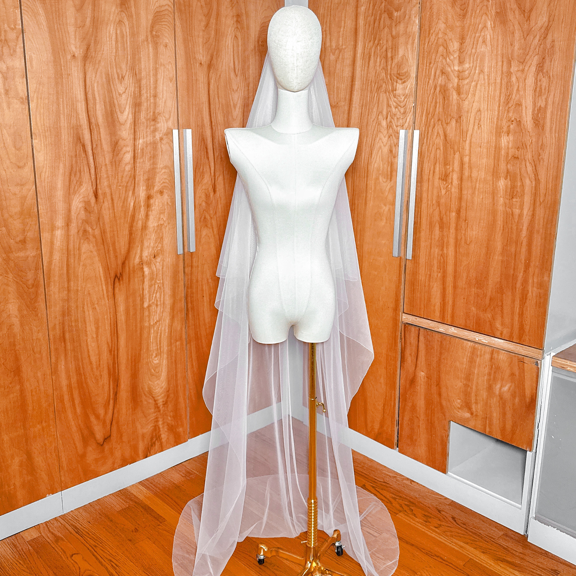 Chapel length train pool of a simple two tier bridal veil with pencil edge.
