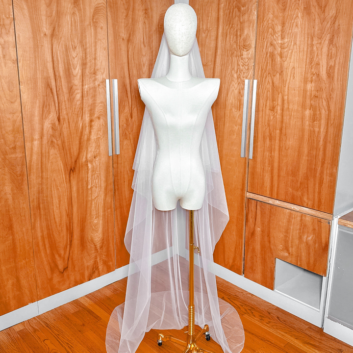 Chapel length train pool of a simple two tier bridal veil with pencil edge.