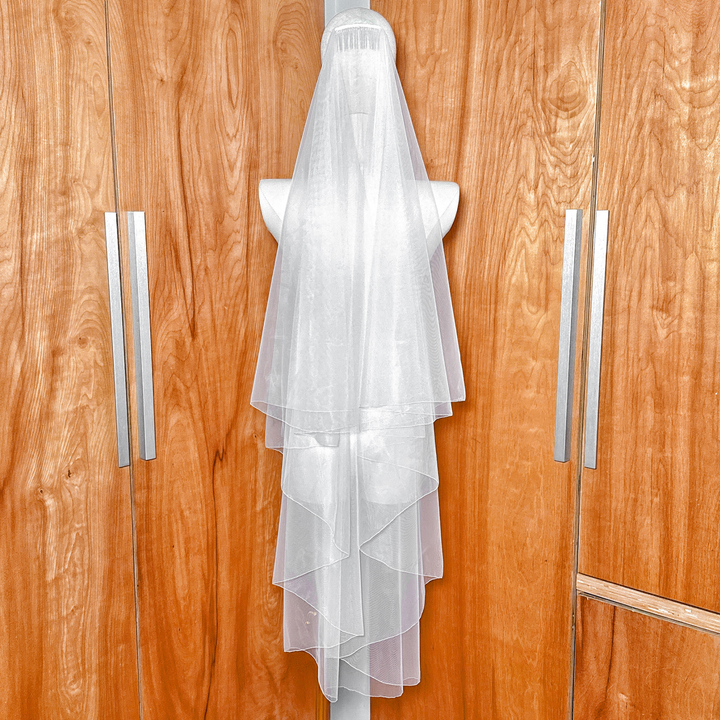 Back view showing the transparent layers of a simple two tier wedding veil with a pencil edge.