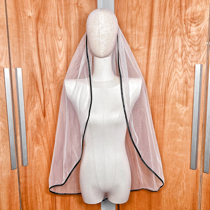 Single tier black ribbon trim wedding veil in fingertip length displayed on a bridal bust.