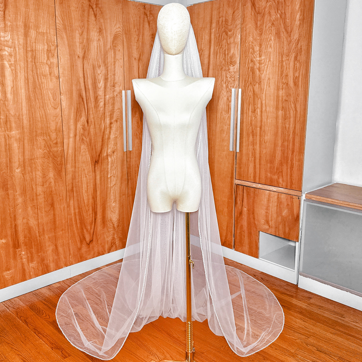 Cathedral length bridal veil made of soft tulle featuring an elegant beaded edge design.