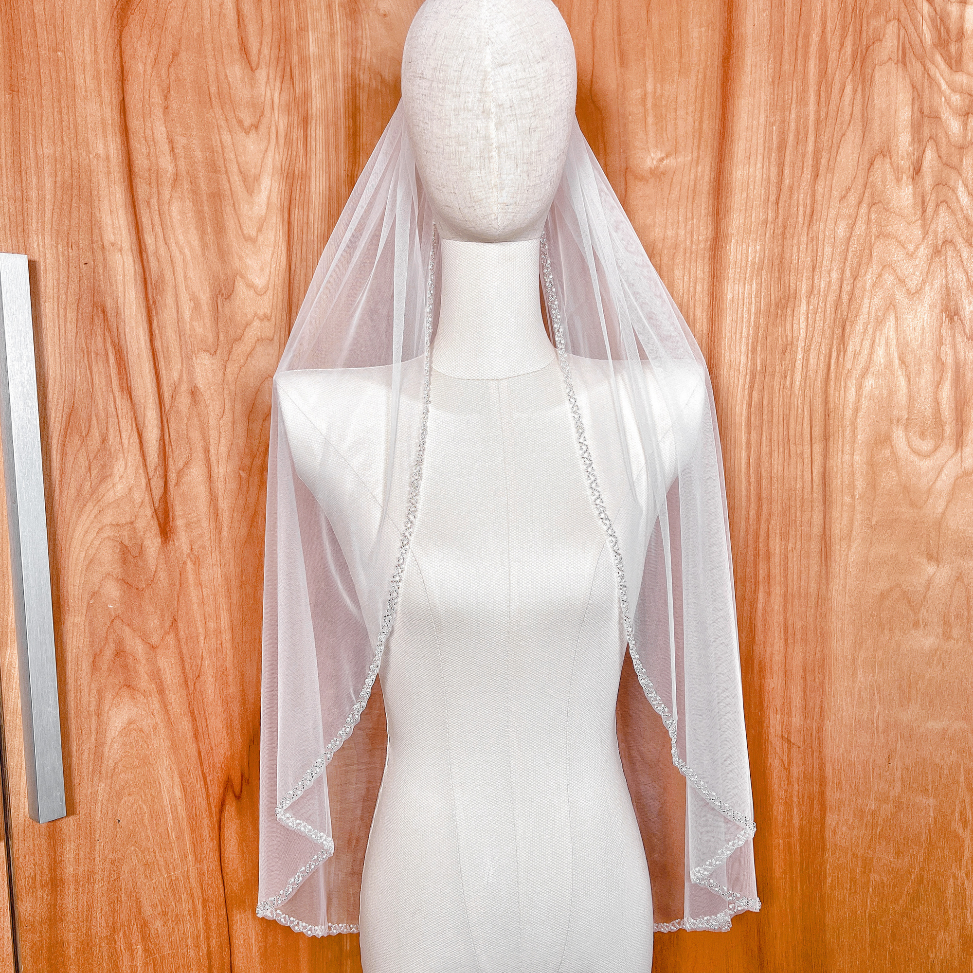 Fingertip length wedding veil made of premium soft tulle with a delicate pearl beaded edge.