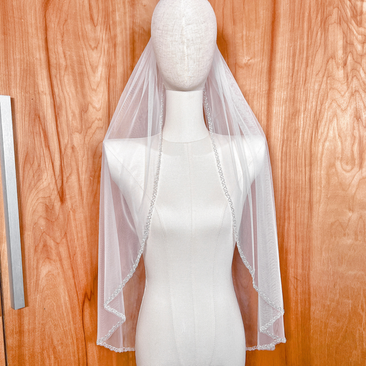 Fingertip length wedding veil made of premium soft tulle with a delicate pearl beaded edge.