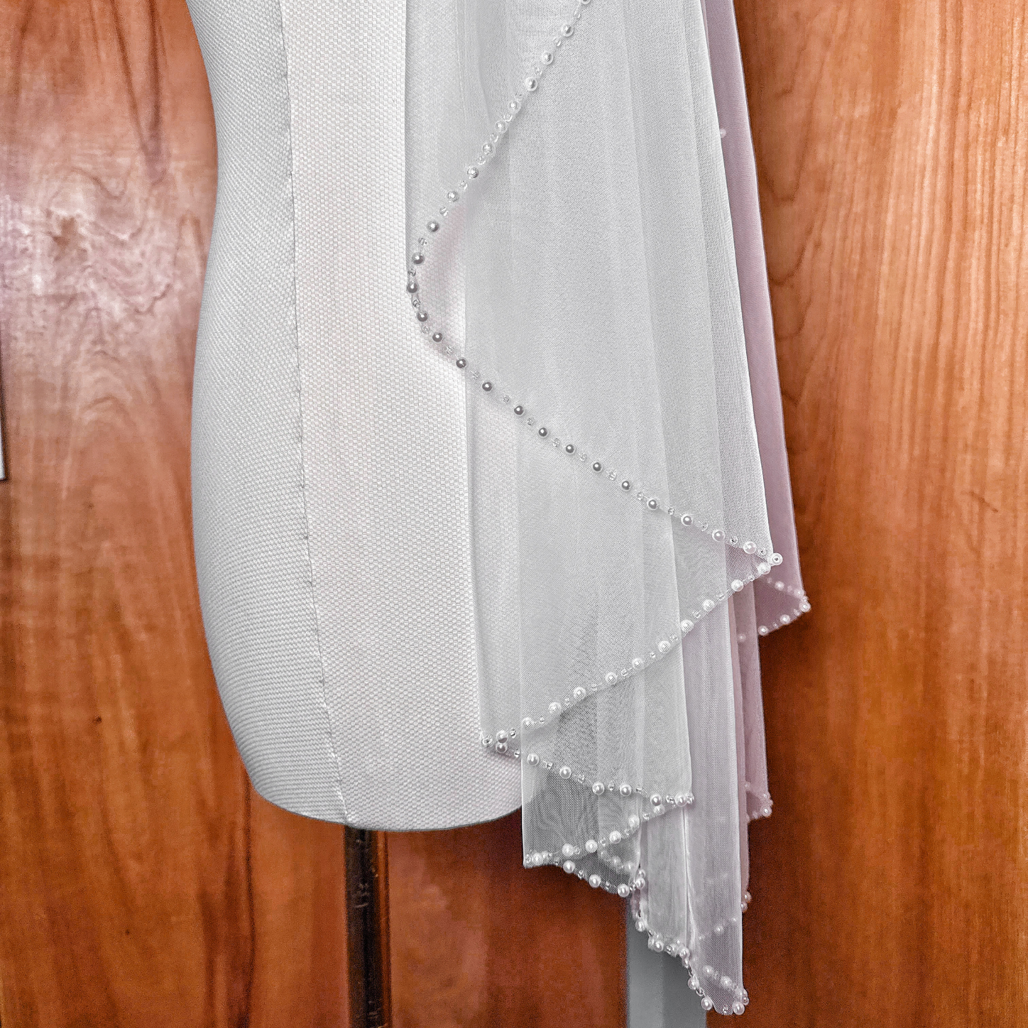 High-quality soft tulle wedding veil in fingertip length with a sophisticated pearl lined finish.