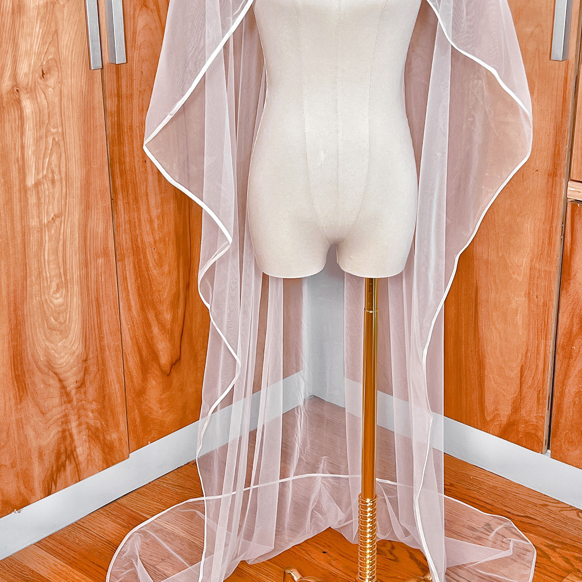 Floor length ribbon trim wedding veil in soft tulle showcasing the fabric drape.