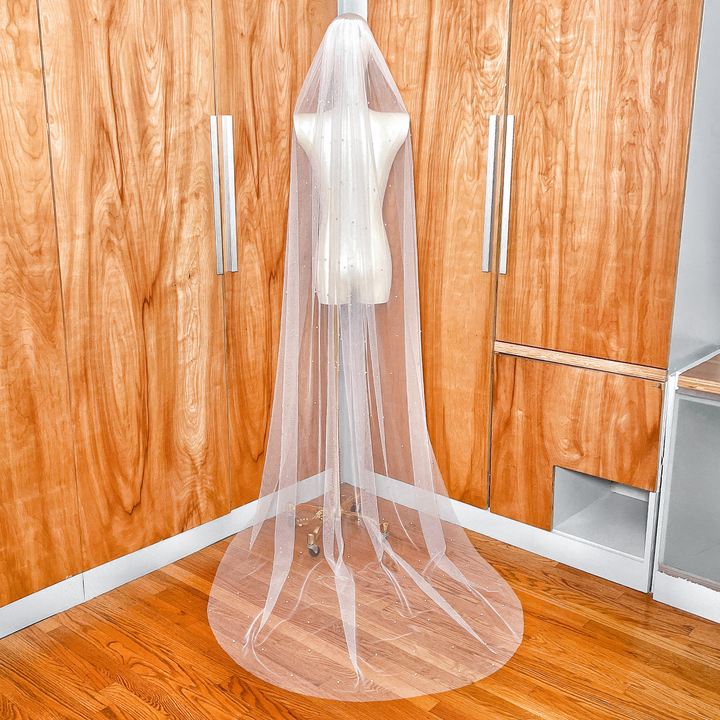 Rear view of a scattered pearl wedding veil in chapel length, highlighting the airy movement of the soft tulle fabric.