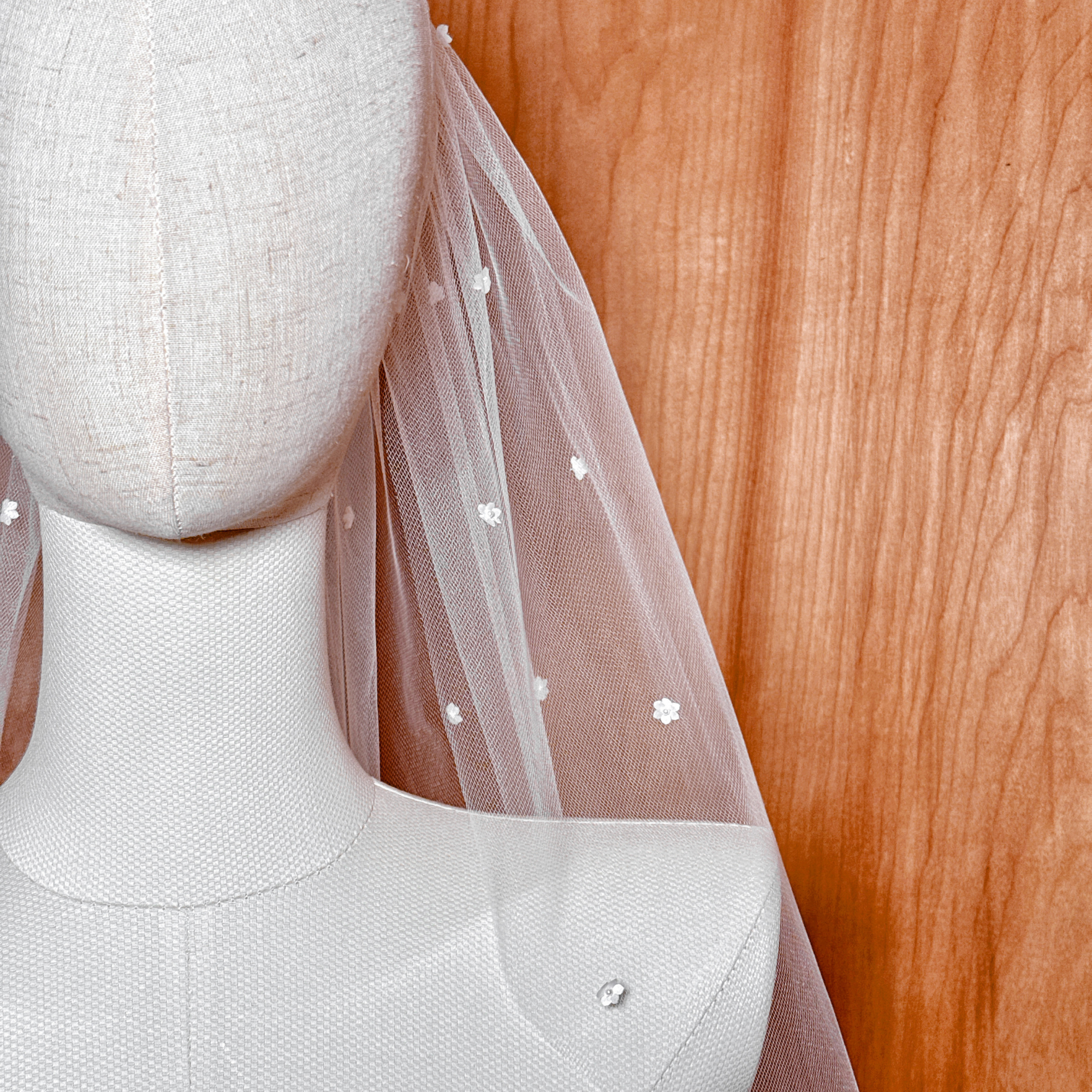 A macro shot detailing a single silk flower with its Swarovski pearl center to highlight product craftsmanship.