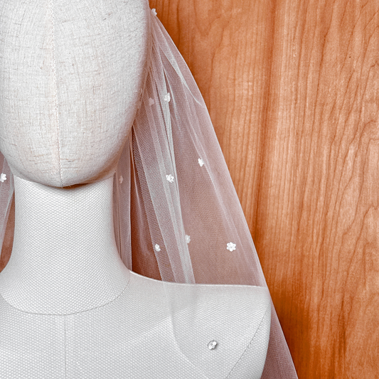 A macro shot detailing a single silk flower with its Swarovski pearl center to highlight product craftsmanship.