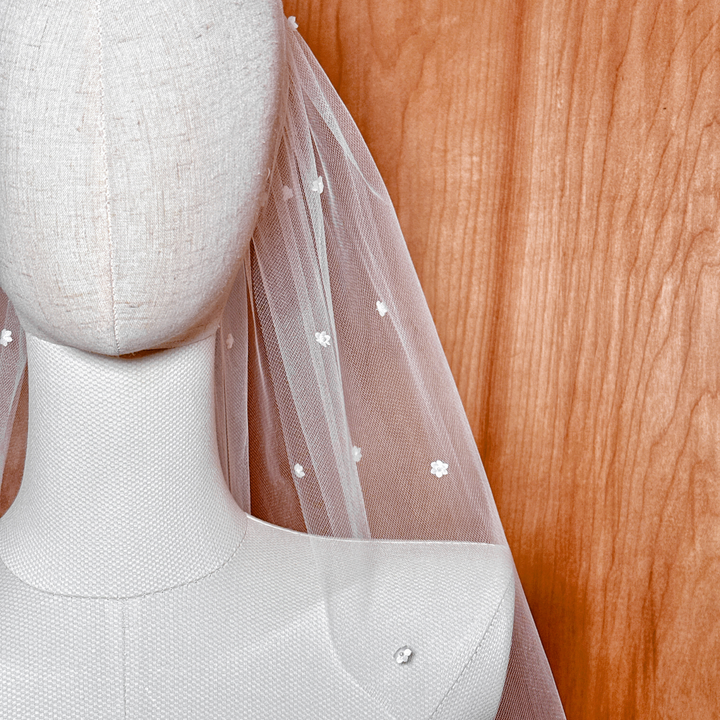 A macro shot detailing a single silk flower with its Swarovski pearl center to highlight product craftsmanship.