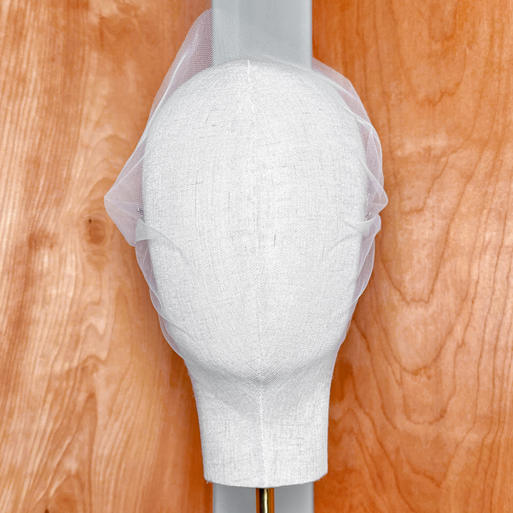 Close-up detail of the delicate mesh fabric on a tulle bandeau wedding veil.