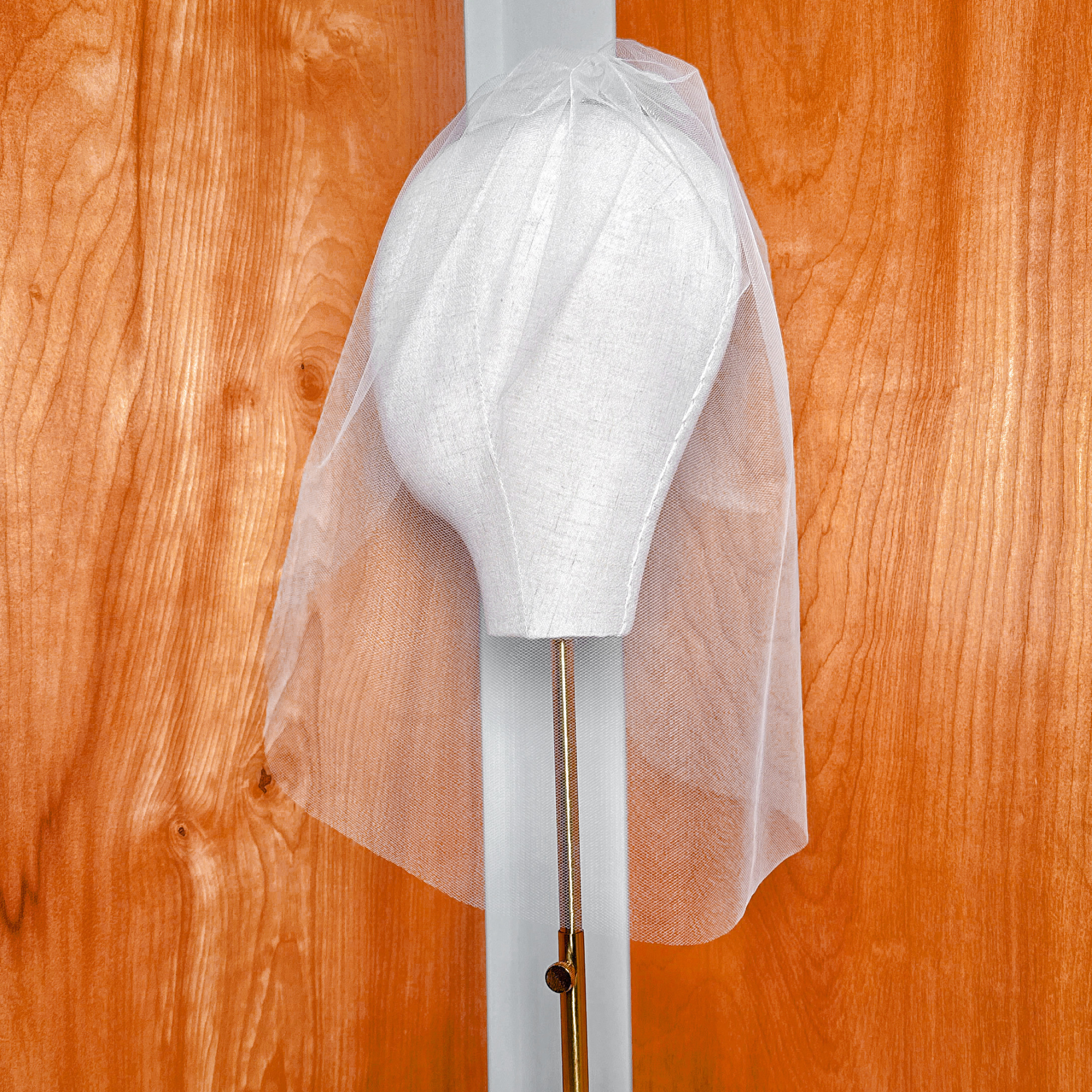 Rear view focusing on the gathered gathering and attachment mechanism of the tulle birdcage wedding veil.