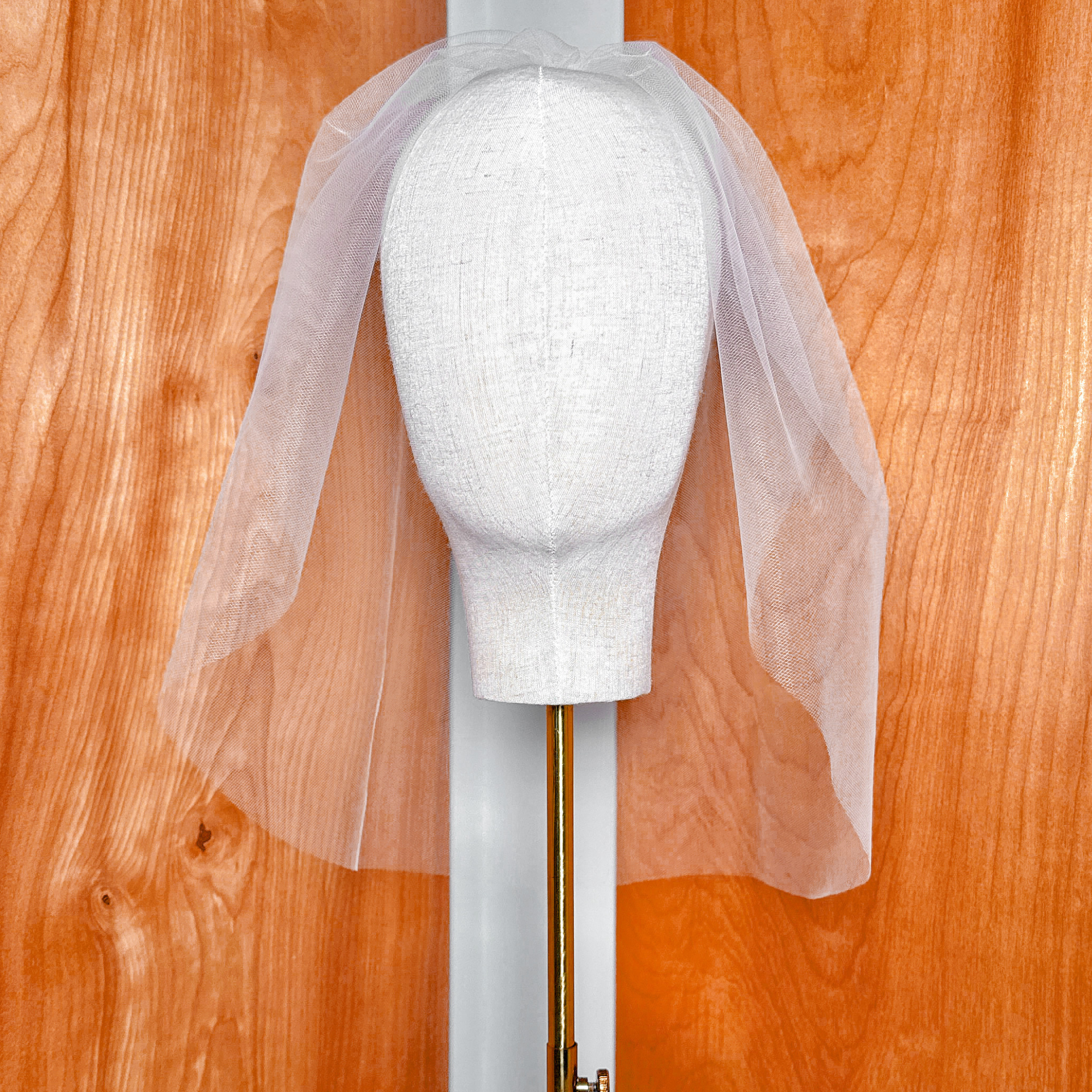 Overhead perspective of a tulle birdcage wedding veil illustrating the full drape and coverage area.