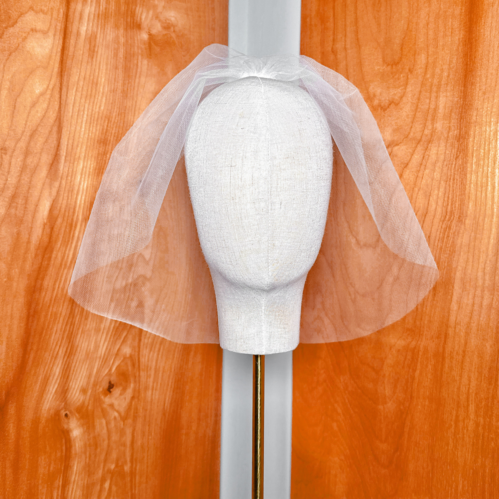 Angled studio shot of the Tulle Birdcage Wedding Veil - Vintage Style Civil Ceremony, demonstrating the classic retro blusher length and volume on a professional dress form mannequin.