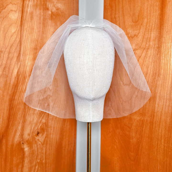 Angled studio shot of the Tulle Birdcage Wedding Veil - Vintage Style Civil Ceremony, demonstrating the classic retro blusher length and volume on a professional dress form mannequin.