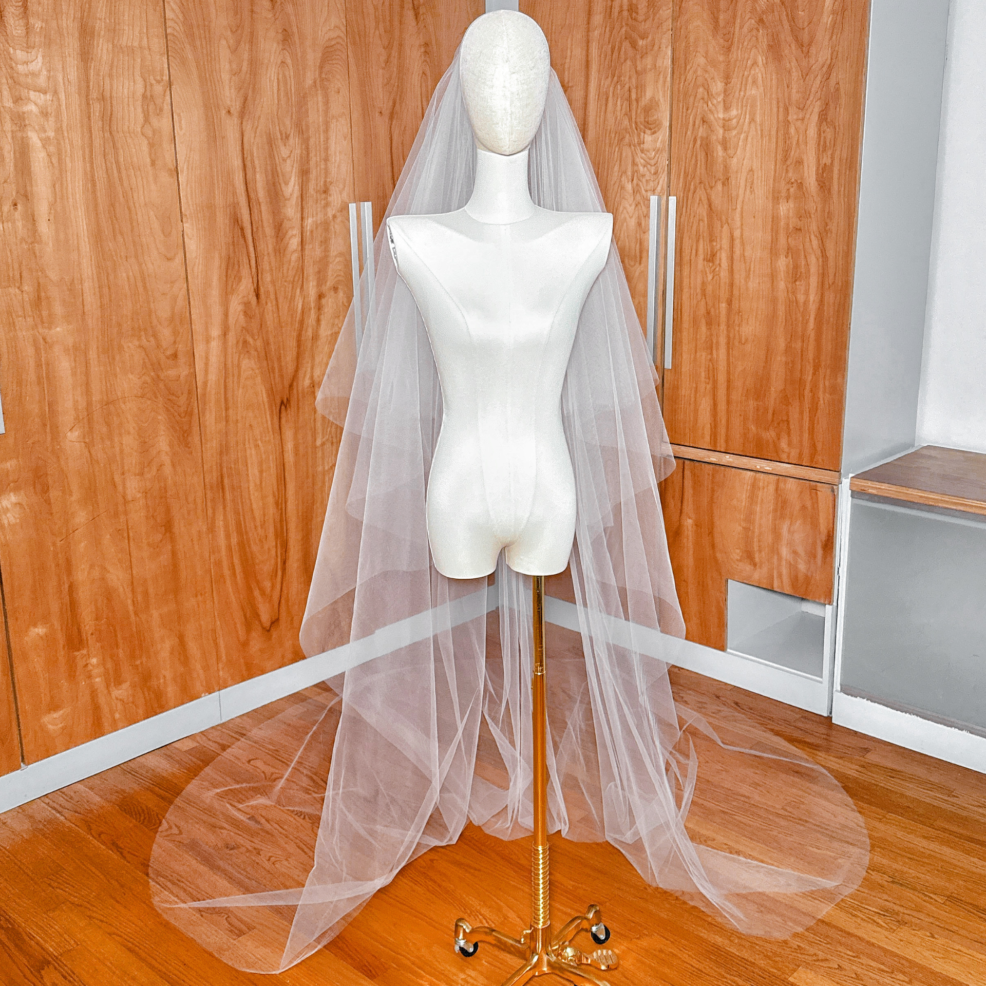 Bridal ensemble featuring a two-tier cathedral tulle wedding veil with a raw edge and versatile blusher.
