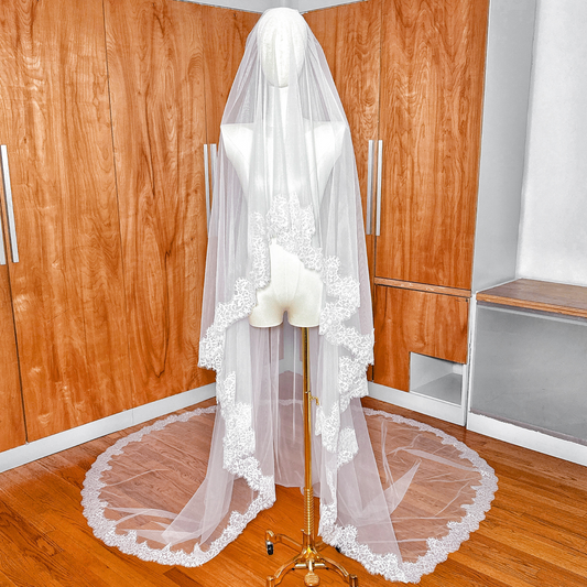 Front view of a two tier Chantilly lace trim cathedral veil displayed on a mannequin.