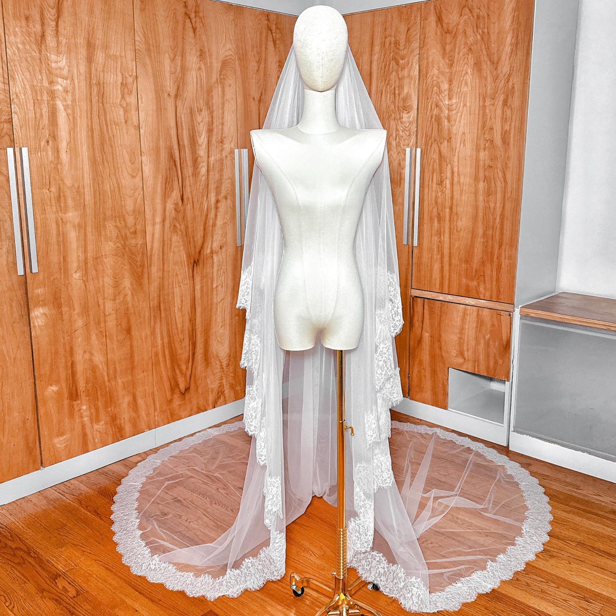Two-tier cathedral length wedding veil with fine Chantilly lace borders on a mannequin.