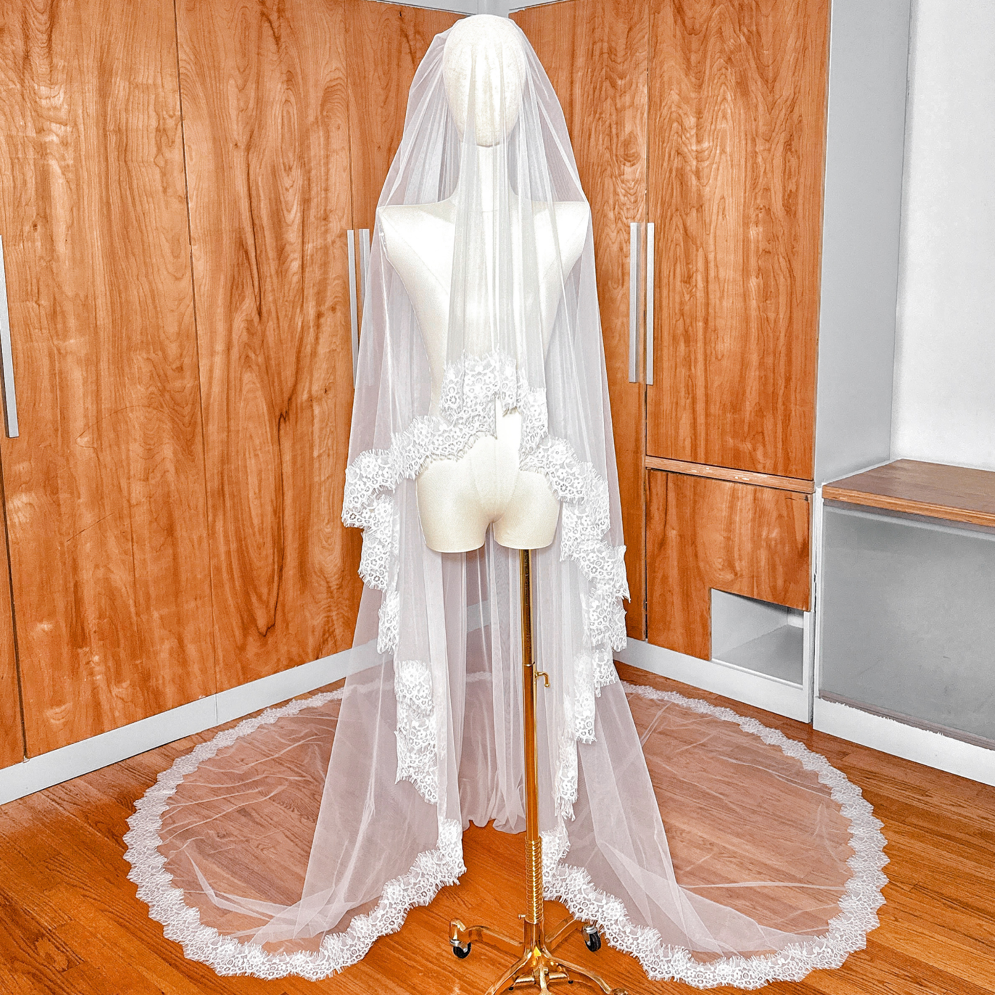 Front view of a Two Tier Chantilly Lace Wedding Veil in cathedral length displayed on a mannequin, showing the delicate lace trim.