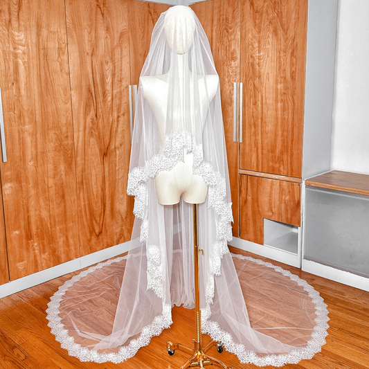 Front view of a Two Tier Chantilly Lace Wedding Veil in cathedral length displayed on a mannequin, showing the delicate lace trim.