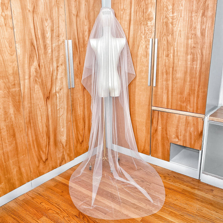 Back view of a two-tier chapel length bridal veil showing the long cathedral-style tier with a clean raw edge finish.
