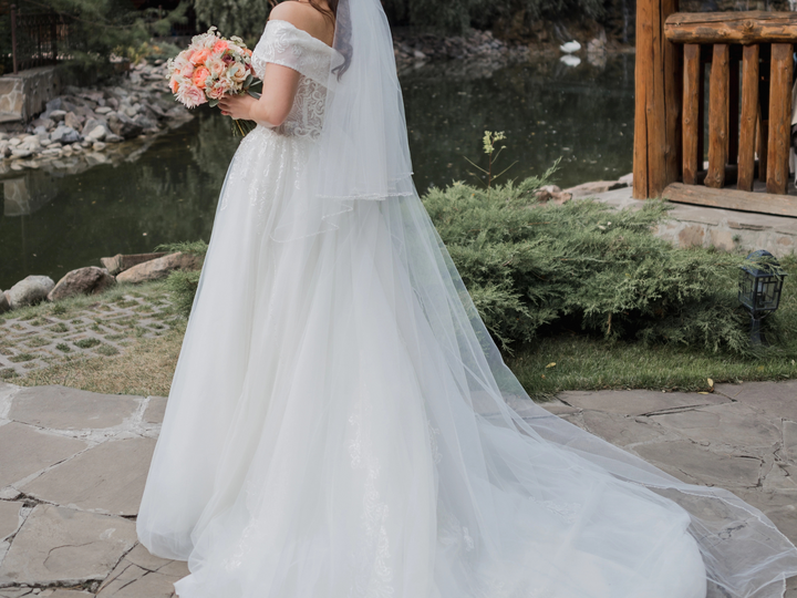 Two tier crystal beaded edge wedding veil with blusher in cathedral length on a bride.