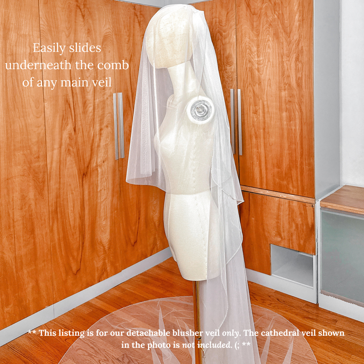 A two-tier bridal look featuring a detachable blusher veil with a modern raw cut edge.