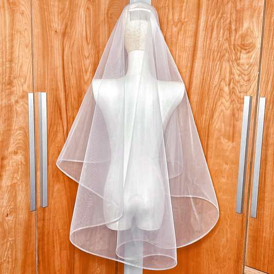 Back view of the two tier fingertip veil with horsehair trim highlighting the elegant drape and length.