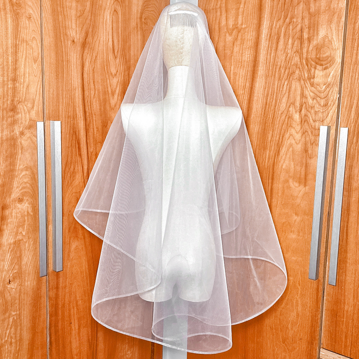 Back view of the two tier fingertip veil with horsehair trim highlighting the elegant drape and length.