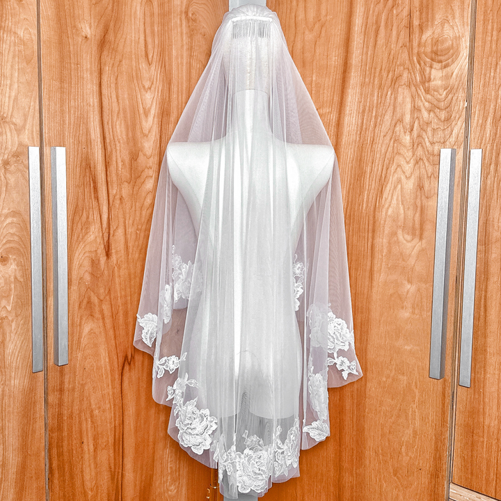 Back view of a two tier floral lace wedding veil in a fingertip length cut.