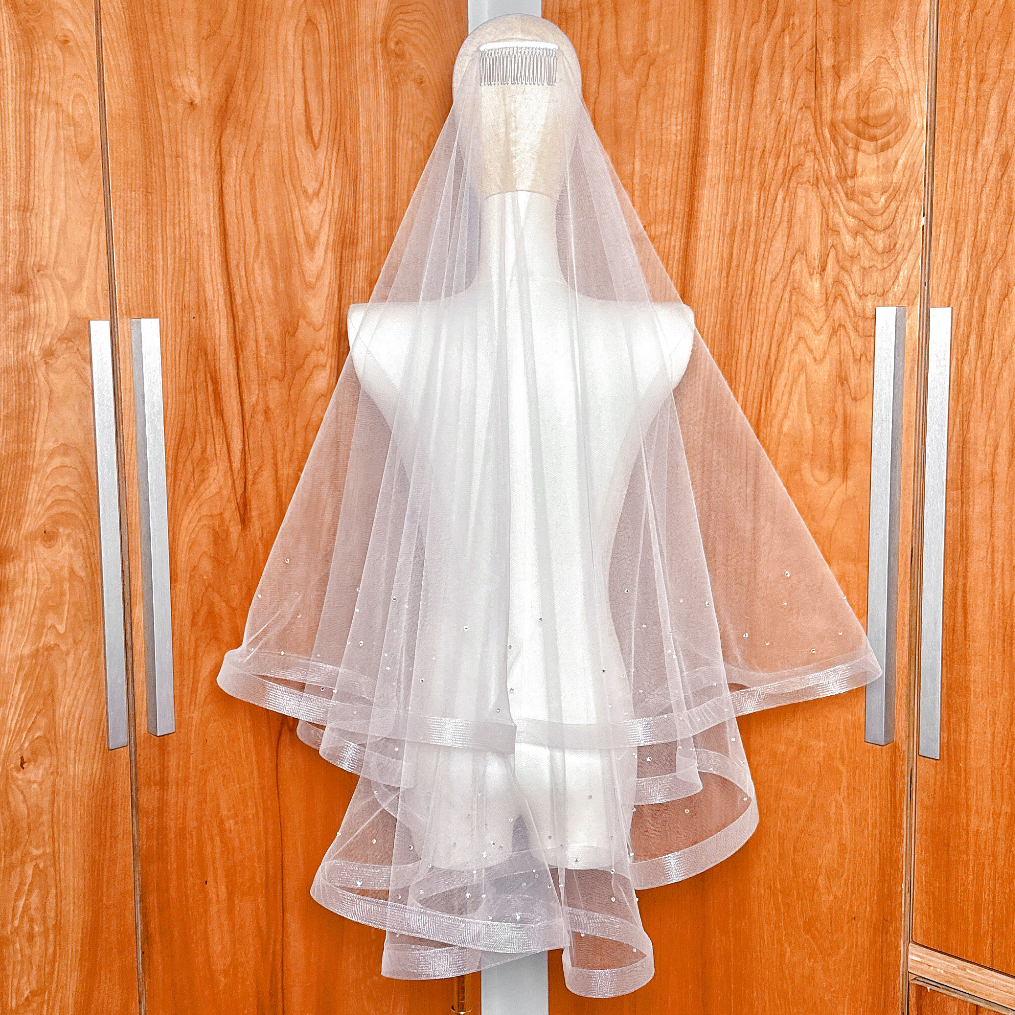 Back view of the volume and layers of a two tier horsehair wedding veil with scattered rhinestones.