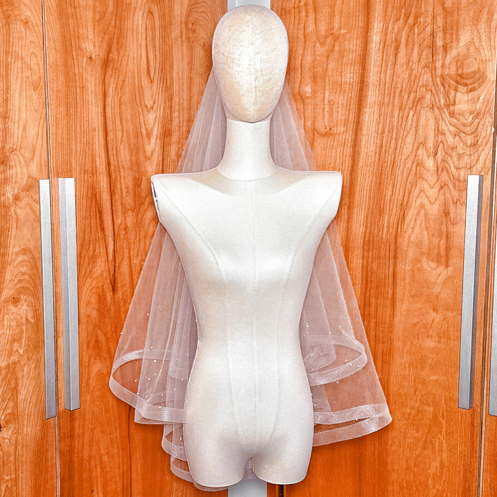 Studio display of a two tier horsehair wedding veil with scattered rhinestones on a bridal form.
