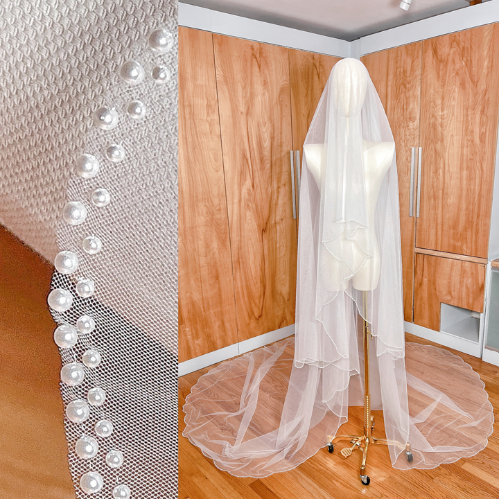 Two-tier pearl edge wedding veil with blusher in cathedral length displayed on a mannequin.