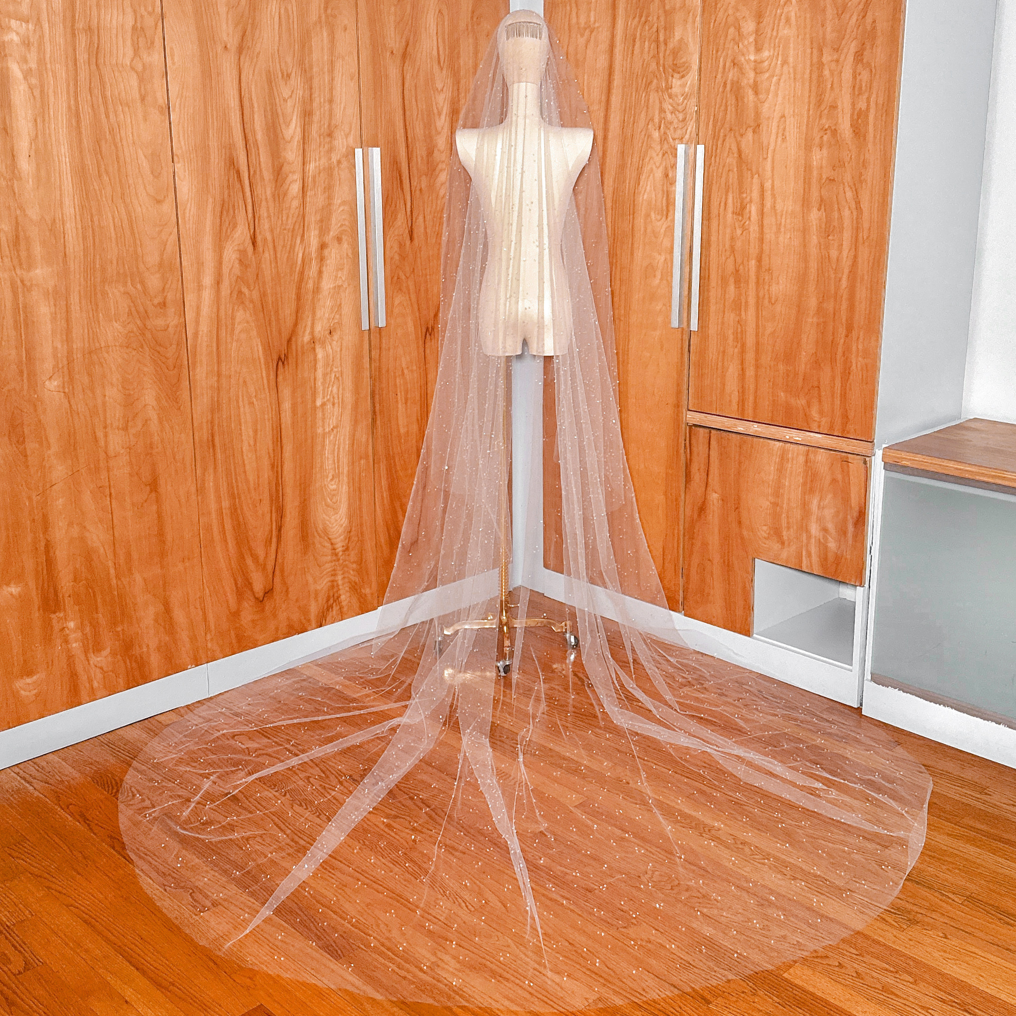 Professional bridal mannequin showcasing the tiered layers of a scattered crystal beaded cathedral length wedding veil.