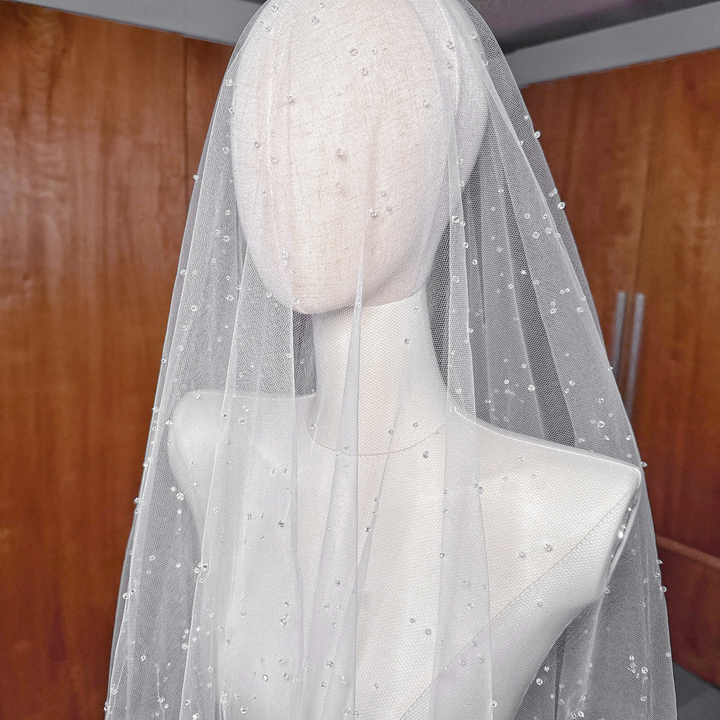 Close-up of hand-placed accents on a two-tier scattered crystal beaded veil in cathedral length.