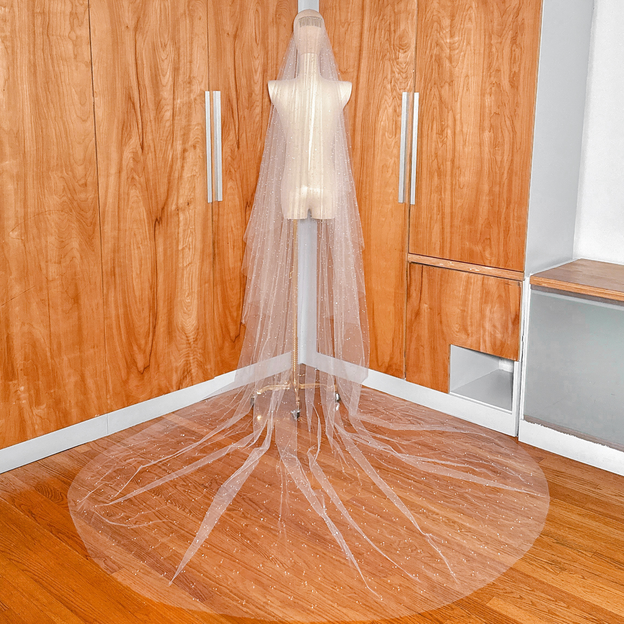 Full-length back view of a 118-inch two-tier scattered crystal beaded cathedral veil draped elegantly over a mannequin.