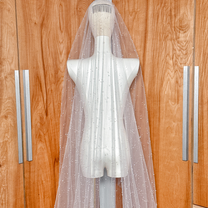 Secure metal comb attachment on a two-tier scattered crystal beaded cathedral veil shown on a mannequin head.