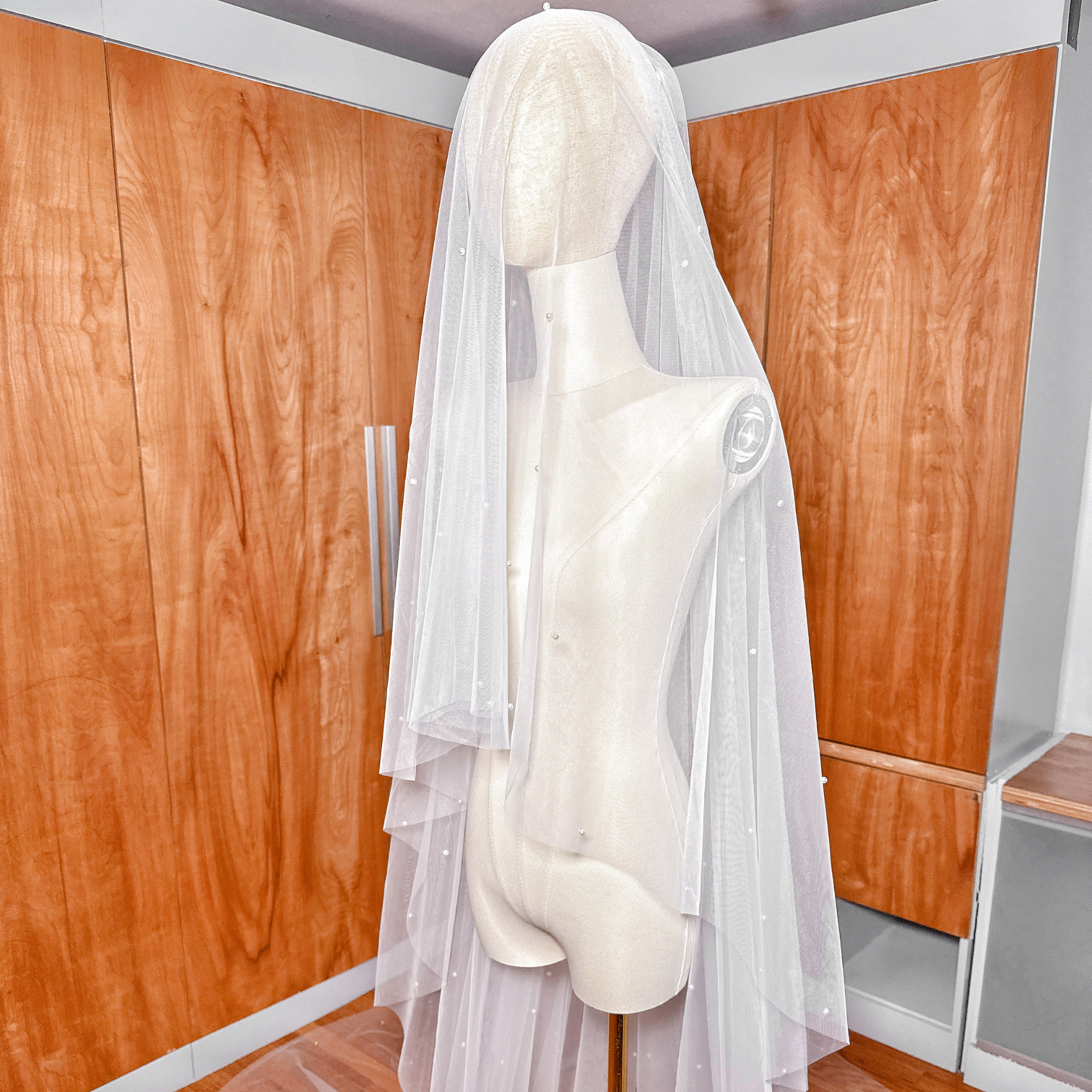 Long cathedral length two tier scattered pearl wedding veil with a sheer blusher layer.