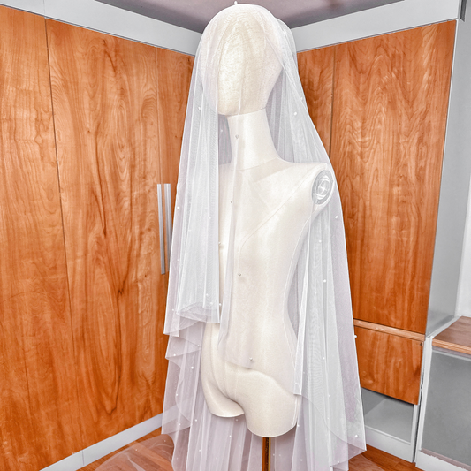 Long cathedral length two tier scattered pearl wedding veil with a sheer blusher layer.