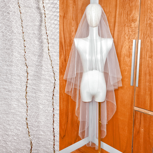 Two tier wedding veil with a gold metallic edge and blusher shown in waltz length on a mannequin.